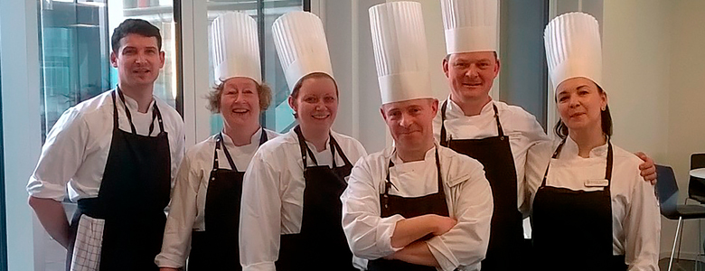 Head Chef Jacob Justesen (med den kokkehue der rækker højst) sammen med sit team hos Maersk Oils danske forretningsenhed.